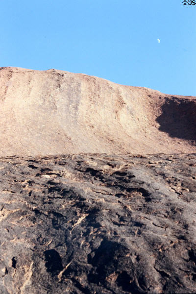 Tiny moon in a blue sky above Uluru (aka Ayers Rock). Australia.