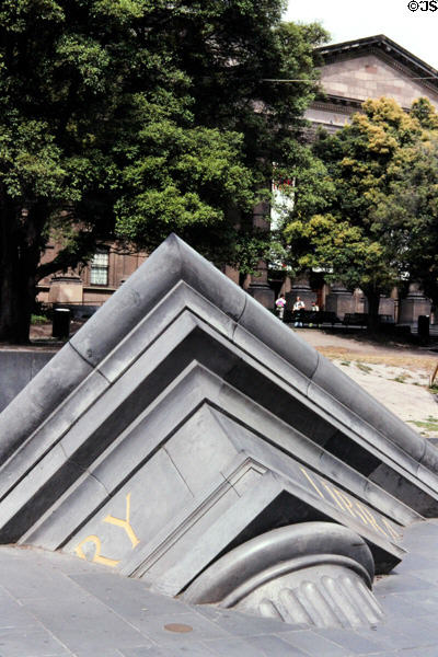 Sculpture of partial column & pediment sink into sidewalk at Melbourne library. Melbourne, Australia.
