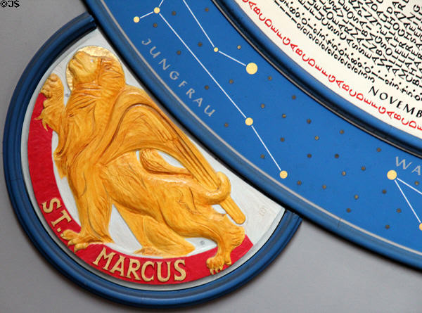 Lion symbol of Evangelist St Mark on saints day calendar clock at St Mary's Church. Lübeck, Germany.