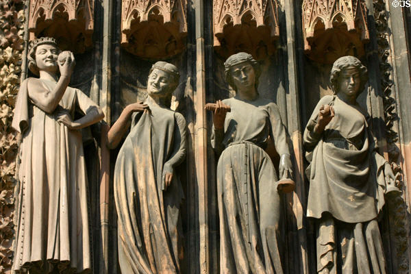 Foolish virgins holding their lamps upside-down flanking left door of Cathedral. Strasbourg, France.