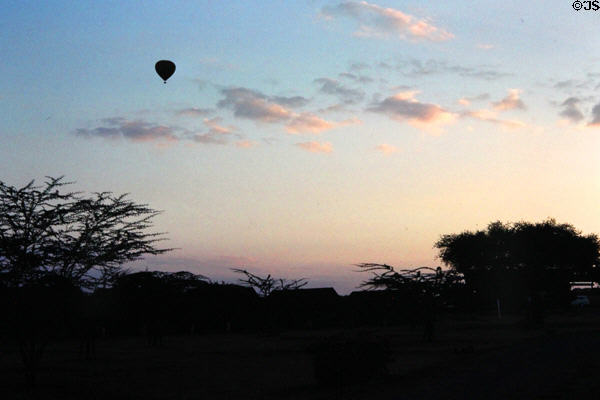 Hot air balloon drifts over Masai Mara National Reserve causing ecological concerns. Kenya.