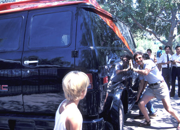 Visitor shows movie strength by lifting hydraulically cantilevered van at Universal Studios. Universal City, CA.