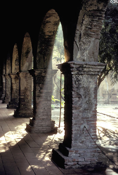 Sunlight streaming through cloister pillars of Mission San Juan Capistrano. Capistrano, CA.