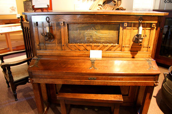 Upright piano (c1906) by Bryon Mauzy of San Francisco with bronze inlay showing Mission Dolores of SF at Mission Inn Museum. Riverside, CA.
