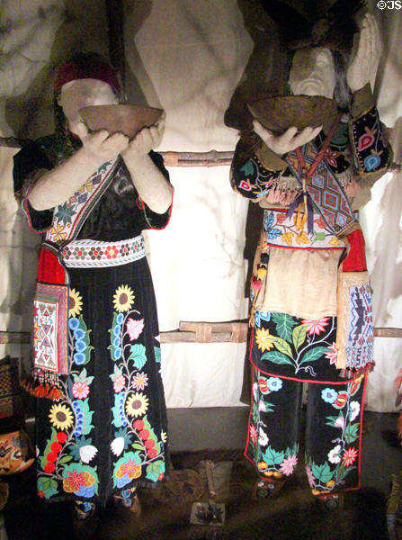 Anishinaabe peoples traditional dress (late 1800s-early 1900s) with wooden bowls at National Museum of the American Indian. Washington, DC.