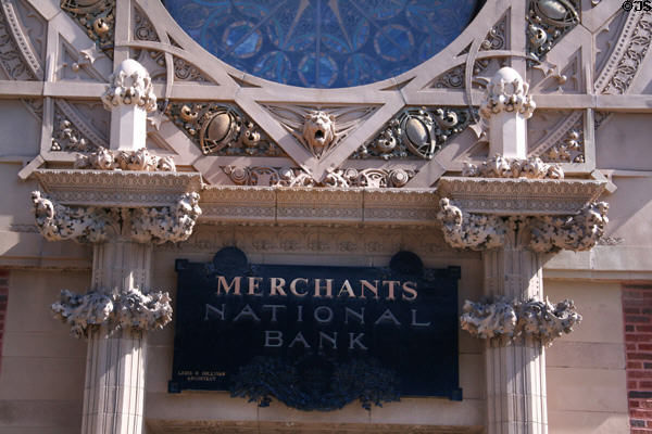 Terra cotta decoration below rose window of Merchants' National Bank with sign. Grinnell, IA.