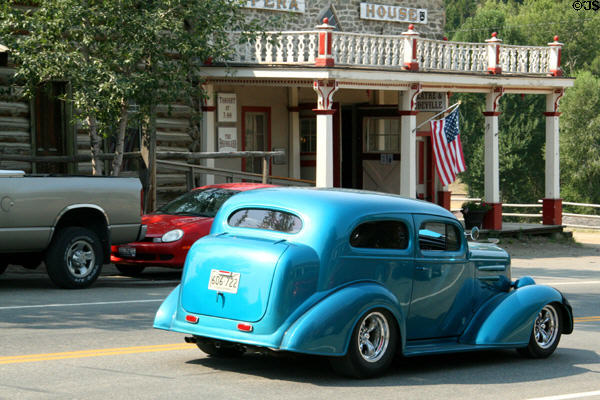 Classic car passes Theater in Smith & Boyd Livery Stable. Virginia City, MT.