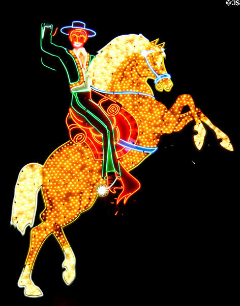 Antique cowboy sign displayed by Neon Sign Museum on Freemont Street at night. Las Vegas, NV.