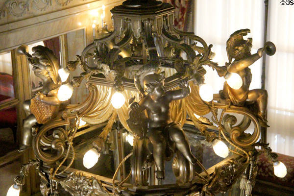 Figures with trumpet on chandelier over stairwell at Marble House. Newport, RI.