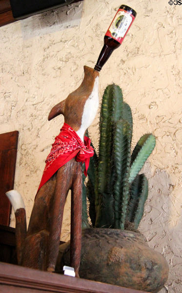 Carved coyote drinking beer at Stockyards Hotel in Thannisch Block Building. Fort Worth, TX.