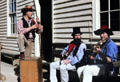 Musicians play on a bench in front of antique building. Ballarat, Australia.