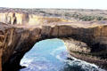 Natural rock arch carved by sea along shore of Victoria in Port Campbell National Park. Australia.