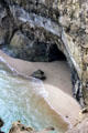 Water rushes towards a cave at base of cliffs in Port Campbell National Park. Australia.