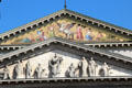 Detail of double pediments of Bavarian National Theatre with carved frieze of Apollo with Muses below a mosaic of Pegasus by Ludwig Schwantehaler. Munich, Germany.