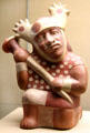 Moche culture ceramic vessel in shape of kneeling warrior with a club from north coast of Peru at Five Continents Museum. Munich, Germany.
