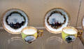 Meissen porcelain yellow cups & saucers painted with Dutch landscapes at Meissen porcelain museum at Lustheim Palace. Munich, Germany.