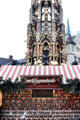 Booth of figurines made from prunes in front of Schöner Brunnen at Christmas Market on Frauen Kirche square. Nuremberg, Germany.