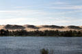 View of the Nile & sand dunes on opposite bank along road to Aswan. Egypt.