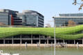 Buildings along Quai d'Austerlitz with green tubing facade on River Seine. Paris, France.