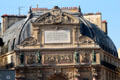 St-Michel Fountain dedication plaque noting construction by city of Paris in reign of Emperor Napoleon III with chimney pots above & frieze level with statues of cardinal virtues below. Paris, France.