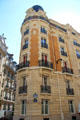 Rounded corner building with tower on rue Jean de la Fontaine. Paris, France.