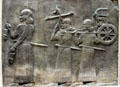 Babylonian relief of servants carrying small chariot from citadel of Dur-Sharukkin at the Louvre Museum. Paris, France.