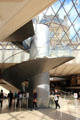 Spiral staircase which leads from pyramid entrance to lower floor at Louvre Museum. Paris, France