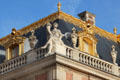 Figure with cornucopia on corner of gilded Mansard roof of Marble Court at Versailles Palace. Versailles, France.