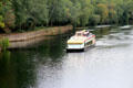 Tour boat on Cher River approaching Chenonceau Chateau. Chenonceau, France.