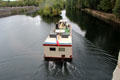 Tour boat on Cher River after passing under Gallery bridge of Chenonceau Chateau. Chenonceau, France.
