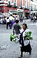 Native leaf seller walks streets of Puebla. Mexico.