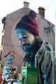 Mural of Saint with birds on end of Bell o'the Brae Tenements. Glasgow, Scotland.