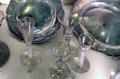 English ale glass engraved with hops leaf & drinking glasses with various stems in front of pewter plates at Hunterian Museum. Glasgow, Scotland.