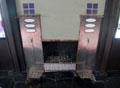 Dining room fireplace metal coal firebox with built-on trivets for kettles by C.R. Mackintosh at Hill House. Helensburgh, Scotland.