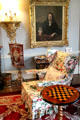Easy chair & game table in parlor below portrait at Brodie Castle. Brodie, Scotland.