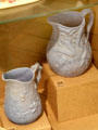 Ceramic white jugs with moulded relief decoration of hop flowers believed to have been made by Charles Toft at Bristol Pottery at Bristol Museum & Art Gallery. Bristol, England.