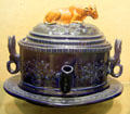 Whimsical earthenware, blue-glazed teapot with cow on lid made by J & J White, Baptist Mills Pottery at Bristol Museum & Art Gallery. Bristol, England.