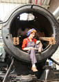 Woman working inside steam engine, probably during wartime, at STEAM Museum of Great Western Railway. Swindon, England.