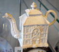 Staffordshire Teapot in shape of mansion with dragon spout draped by human arm at Broadway Museum & Art Gallery. Broadway, England.