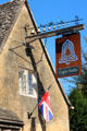 Eight bells pub sign surmounted by eight bells. Chipping Campden, England