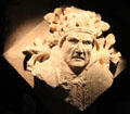 Corbel, jutting out from wall to support something above it, depicting the Pope from St Mary's Abbey at Corinium Museum. Cirencester, England.