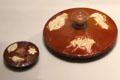 Glazed red earthenware teapot lids with applied white sprigged decoration a forerunner of Jasperware style at World of Wedgwood. Barlaston, Stoke, England.