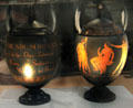 Black Basalt vases with red encaustic decoration of classical figures noting First Day of production on reverse by Wedgwood at World of Wedgwood. Barlaston, Stoke, England.