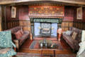 Sitting area around fireplace with Tudor rose panel by Charles Eamer Kempe in Great Parlor at Wightwick Manor. Wolverhampton, England.