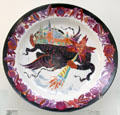 Russian porcelain plate with folk-tale figure carrying off walled city by Maria Lebedeva for SPF at British Museum. London, United Kingdom.