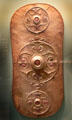 Celtic culture bronze shield with three raised decorative panels inlaid with red glass found near Battersea Bridge in River Thames, London at British Museum. London, United Kingdom.