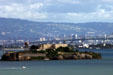 Non-suspension sections of Oakland Bay Bridge seen above Alcatraz & Treasure Islands & against Oakland skyline. San Francisco, CA.