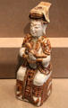 Satchanalai stoneware seated figure with bird from Thailand at Asian Art Museum. San Francisco, CA.