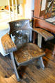 Ornate carved wooden armchair with curved back at Tuolumne County Museum. Sonora, CA.