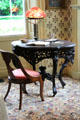 Elaborate round table with Art Nouveau lamp in Art Colony bedroom at Florence Griswold Museum. Old Lyme, CT.